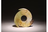 AN ARCHAIC CHINESE CELADON JADE XUANJI DISC