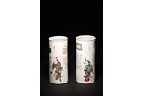 A PAIR OF CHINESE FAMILLE ROSE FIGURES CYLINDRICAL VASES