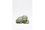 A SMALL CHINESE CELADON JADE CARVING OF LION