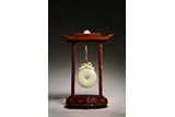 A CHINESE WHITE RUSSET JADE DISC BI ON WOODEN FRAME