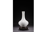 A WHITE GLAZED MOULDED VASE