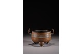 A BRONZE TRIPOD CENSER WITH HANDLES