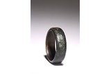 A BLACK AND RUSSET JADE 'TAOTIE' BANGLE