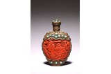 A CARVED CINNABAR LACQUER BRONZE SNUFF BOTTLE