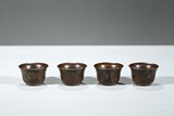 A GROUP OF FOUR BRONZE CUPS