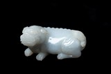 A CHINESE WHITE JADE CARVED RECUMBENT MYTHICAL BEAST
