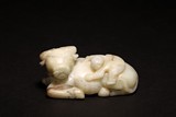 A CHINESE WHITE AND RUSSET JADE BOY ON BUFFALO