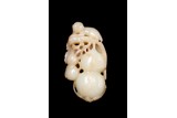 A CELADON JADE CARVING OF 'MONKEY AND PEACHES'