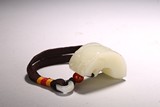 A CHINESE WHITE JADE ARCHED MYTHICAL BEAST HEAD PENDANT