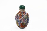 A FAMILLE ROSE MOULDED 'LUOHAN' SNUFF BOTTLE
