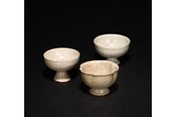 A GROUP OF THREE WHITE GLAZED CUPS