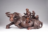 A VERY LARGE ROSEWOOD CARVING OF BUFFALO AND BOYS