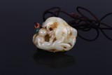 A CHINESE WHITE JADE 'FISH AND BEAST' PENDANT
