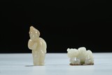 A GROUP OF TWO WHITE AND RUSSET JADE CARVED BOY FIGURES