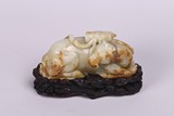 A WHITE AND RUSSET JADE CARVING OF MYTHICAL HORSE