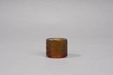 A GOLD SPLASHED AMBER BROWN GLASS ARCHER'S RING